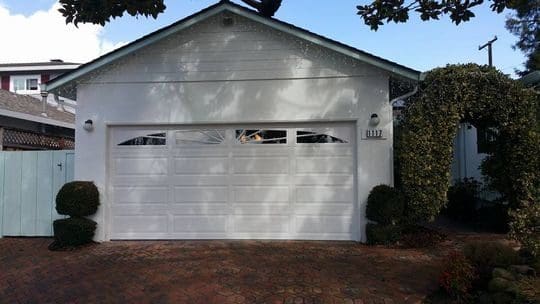 White garage door with windows on house.