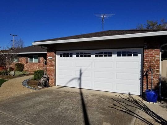 White garage door with windows on a house.