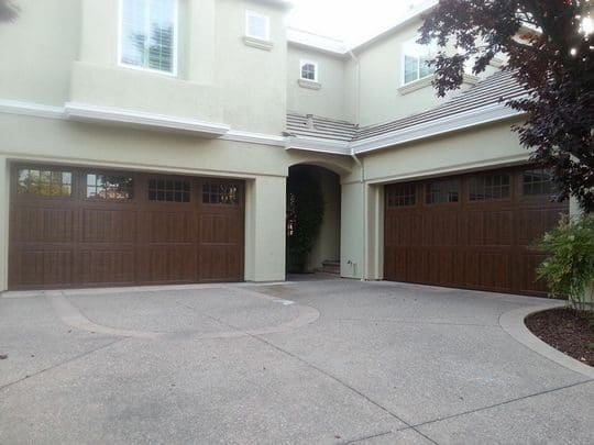 Two wooden garage doors on a house.