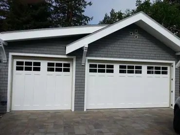 Two white garage doors with windows.