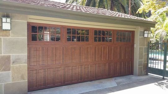 Brown wooden garage door with windows.